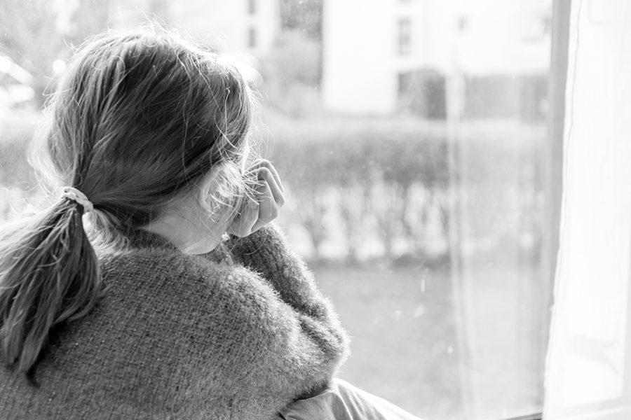 Enfant boudant devant le fenêtre