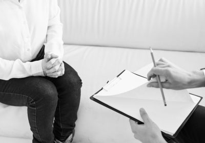 cropped view of man with folder of documents and women putting on indoors. High quality photo